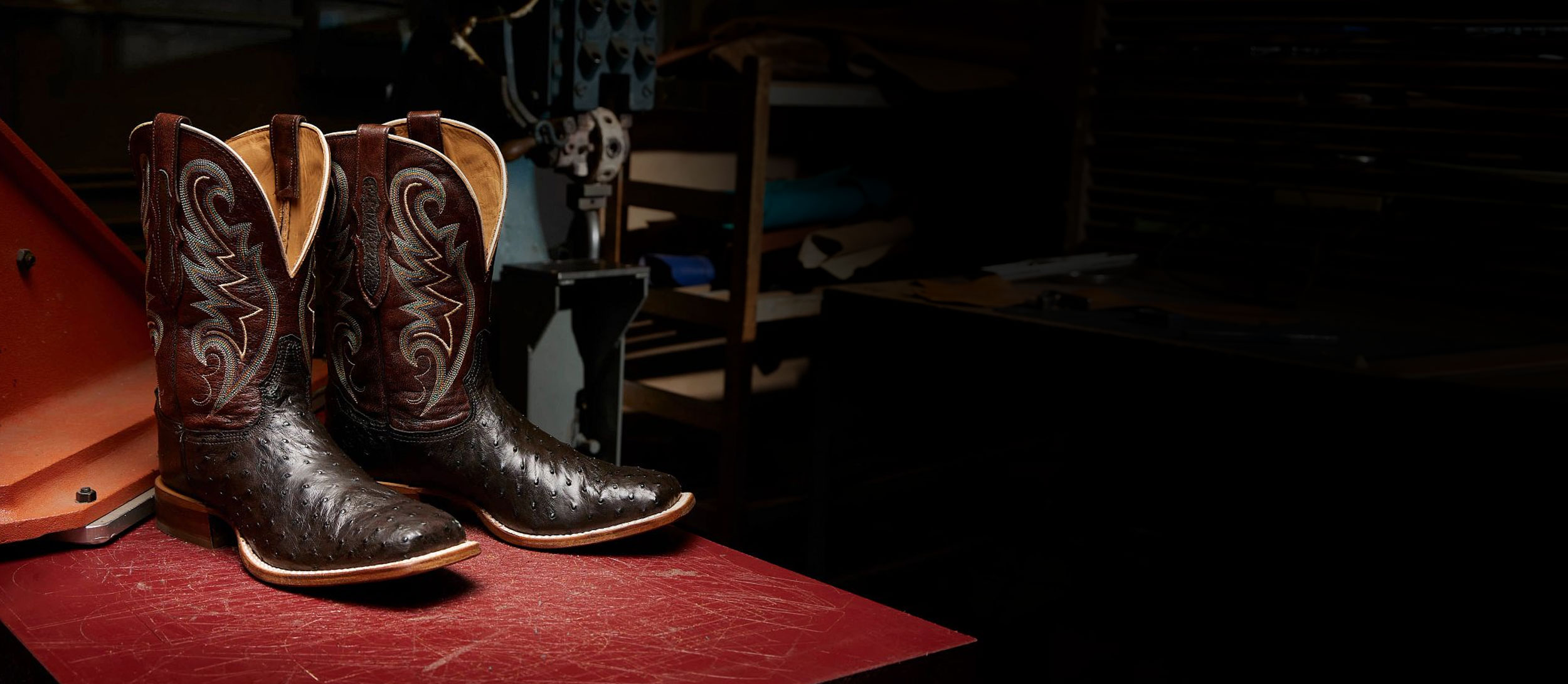 A pair of the Foster 11" Full Quill Ostrich in Sienna brown on a factory table.